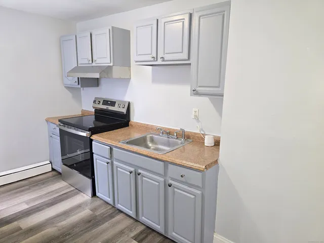 a kitchen with granite countertop a sink and a stove