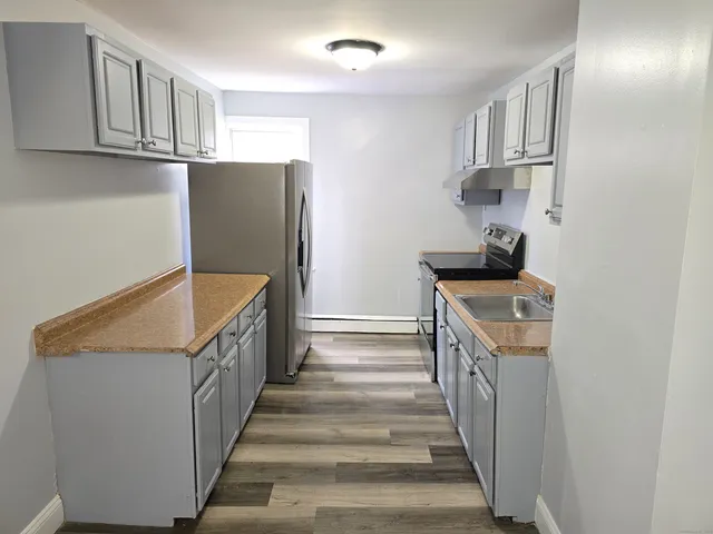 a view of a kitchen with wooden floor and electronic appliances
