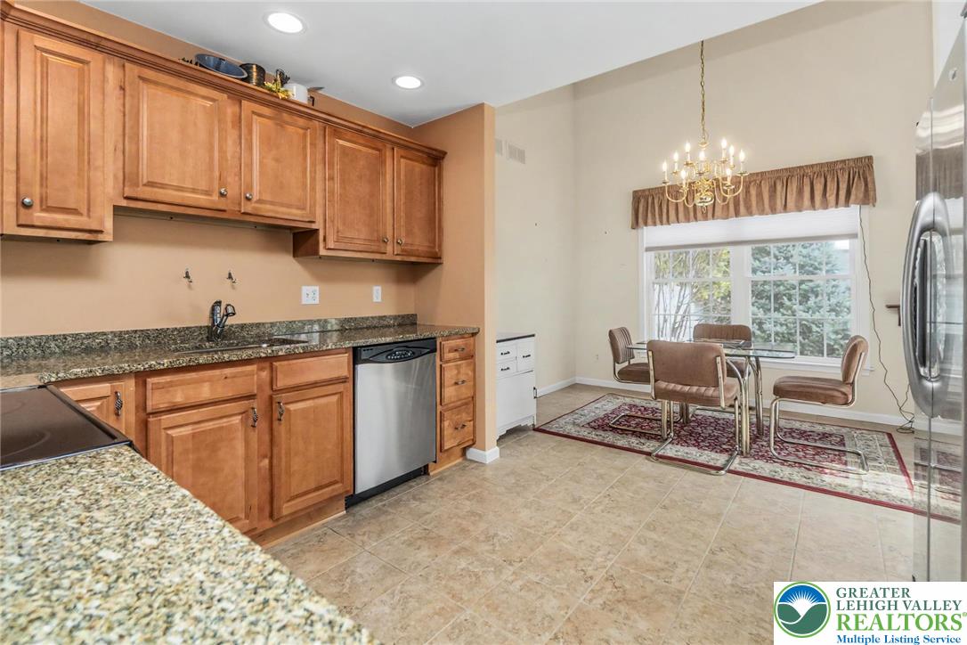 2132 Lexington Avenue Bethlehem, PA 18017 - Photo 14 of 47 a kitchen with stainless steel appliances granite countertop a stove top oven a sink dishwasher a dining table and chairs with wooden floor