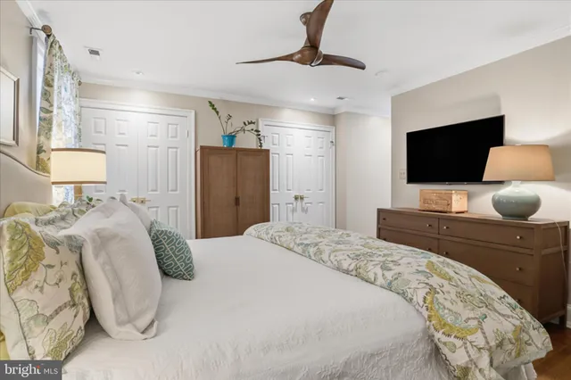 a bedroom with a bed and a flat tv screen on dresser