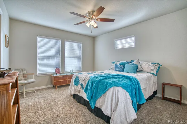 a spacious bedroom with a bed and a chandelier