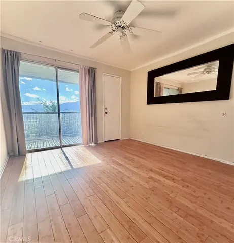 a view of an empty room with wooden floor and a flat screen tv