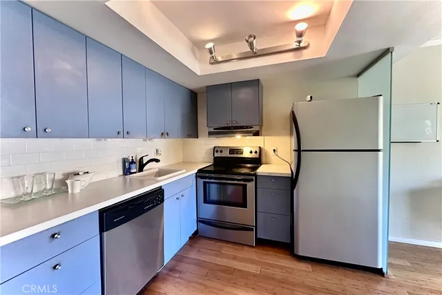 a kitchen with a refrigerator sink and cabinets