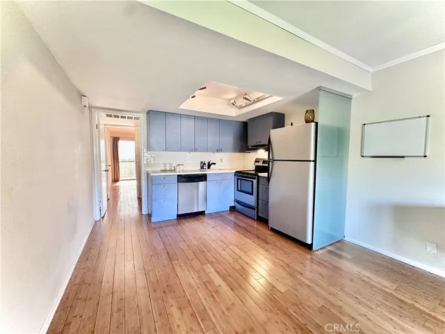 a kitchen with wooden floors and appliances