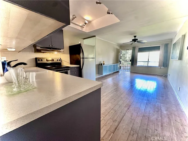 a kitchen with stainless steel appliances granite countertop a sink a stove and a wooden floors