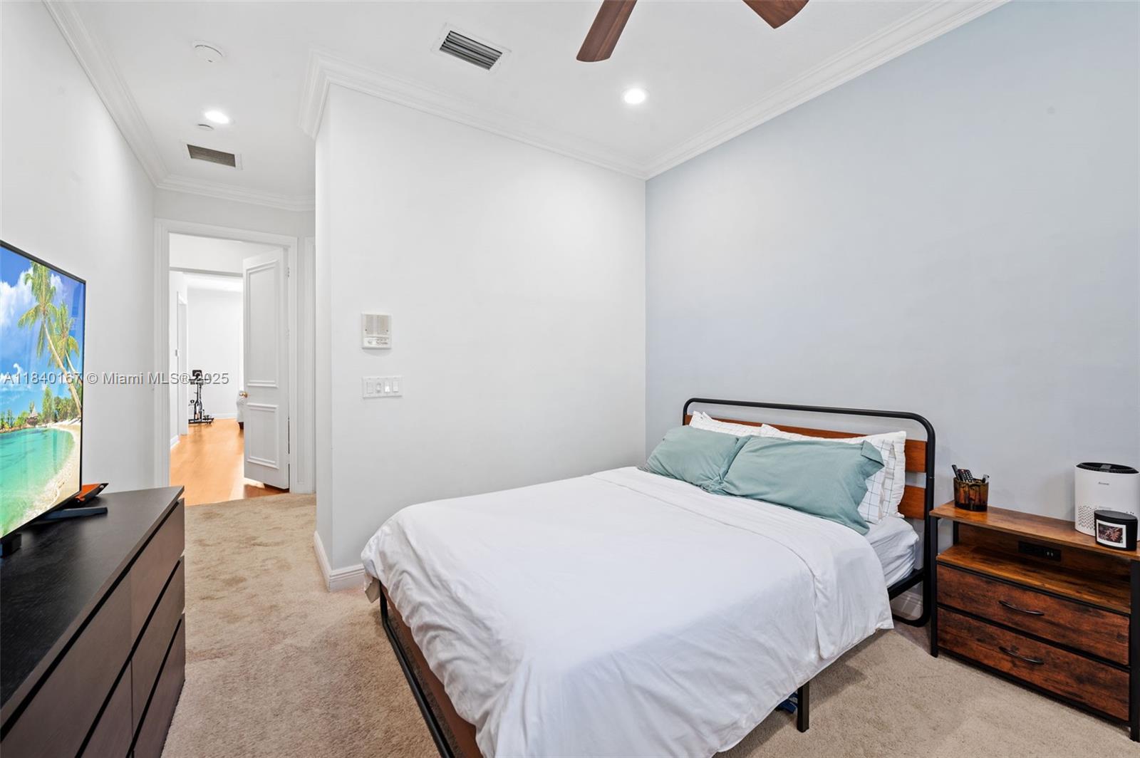 400 Northeast 69th Circle Boca Raton, FL 33487 - Photo 19 of 35 a bedroom with a bed and a flat tv screen on dresser