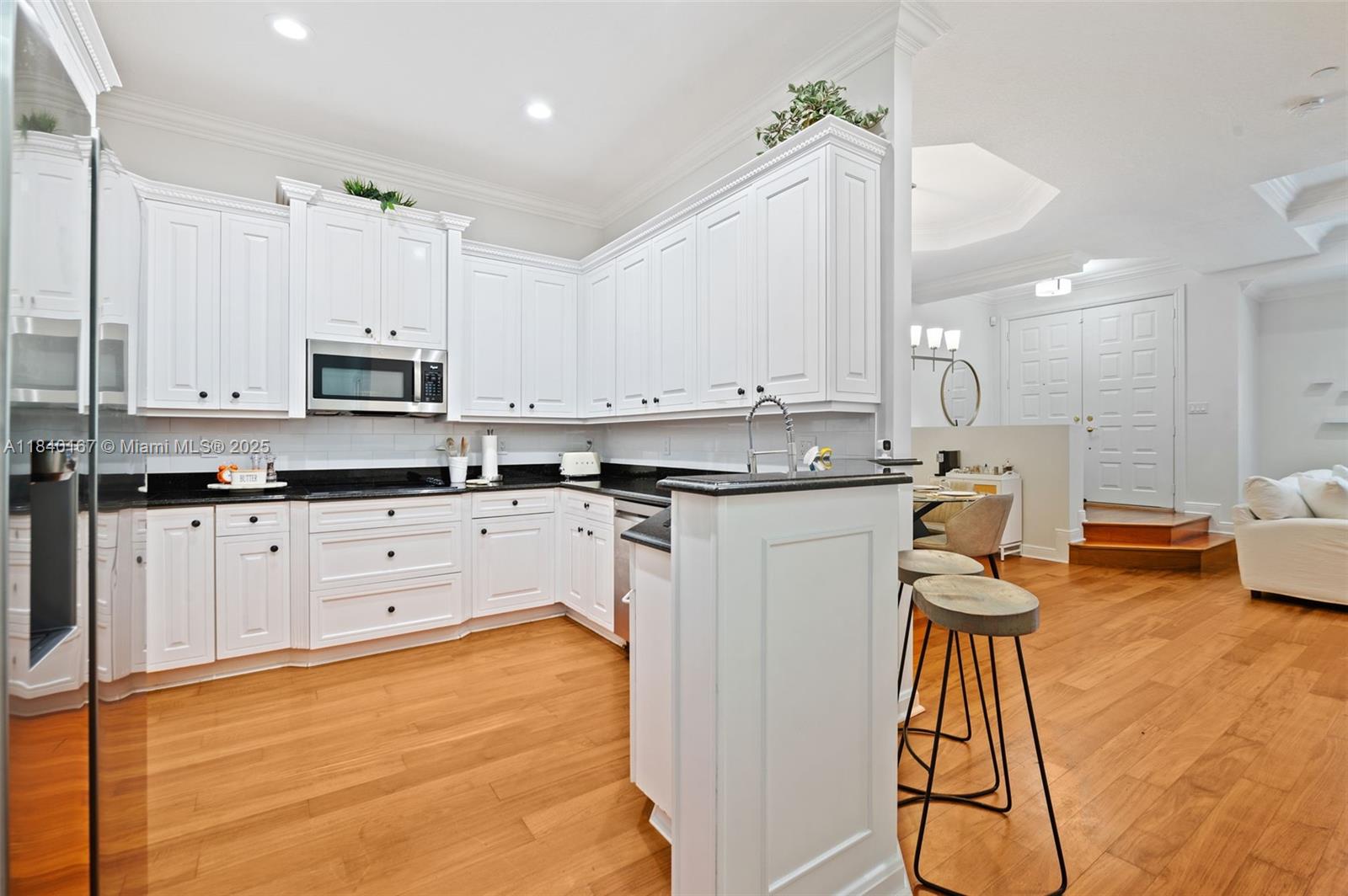 400 Northeast 69th Circle Boca Raton, FL 33487 - Photo 8 of 35 a kitchen with stainless steel appliances granite countertop a stove a sink and white cabinets with wooden floor