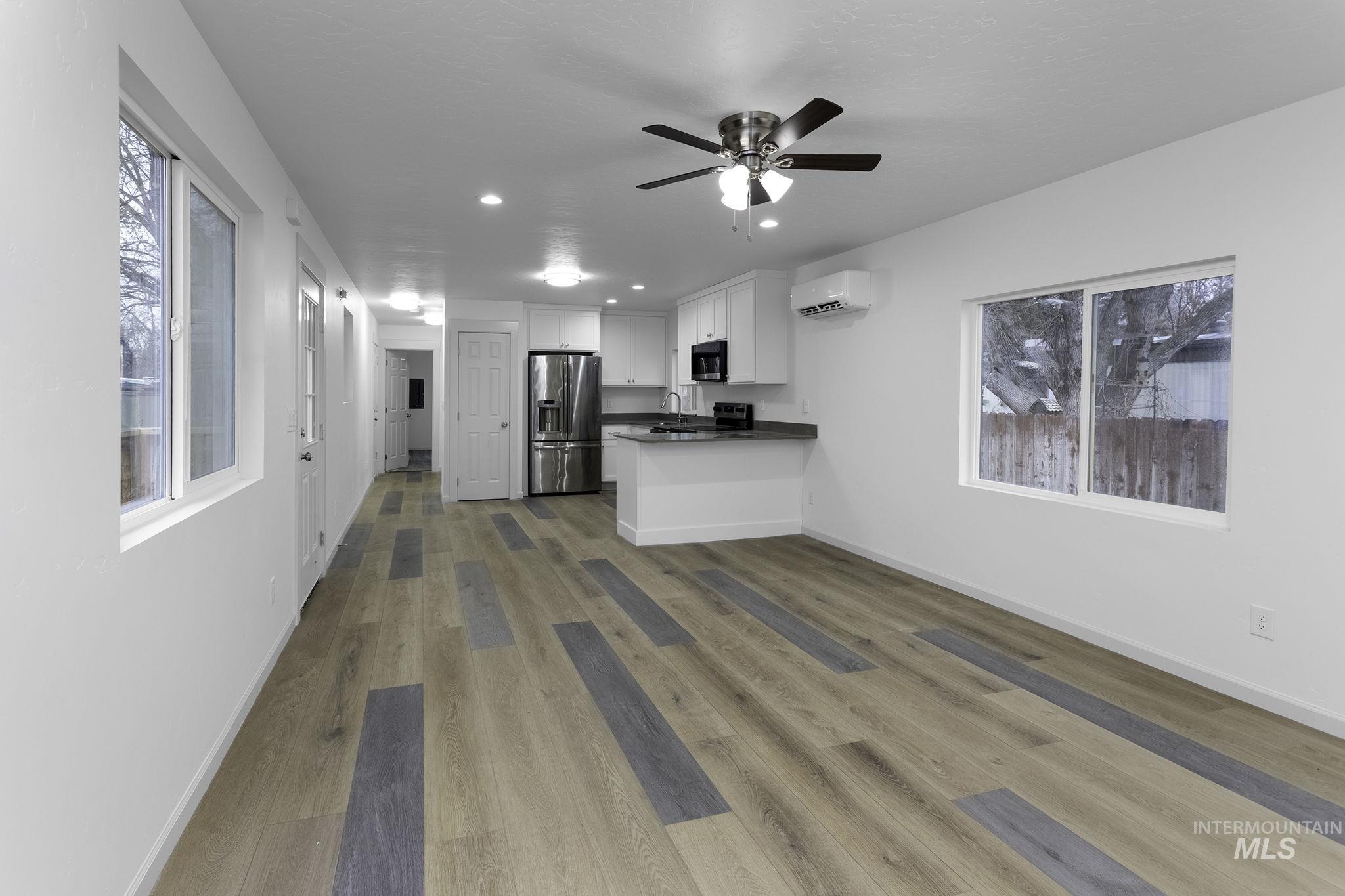 450 Greenleaf Street Boise, ID 83713 - Photo 11 of 17 Kitchen featuring white cabinets, healthy amount of natural light, recessed lighting, dark wood-style flooring, and stainless steel fridge