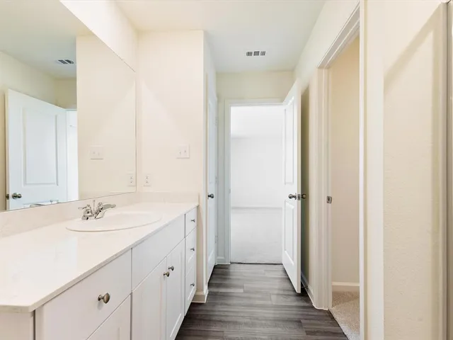 a spacious bathroom with a double vanity sink and a mirror