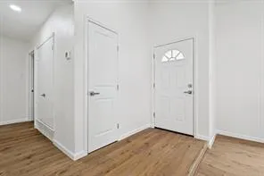 a view of a room with wooden floor and white doors