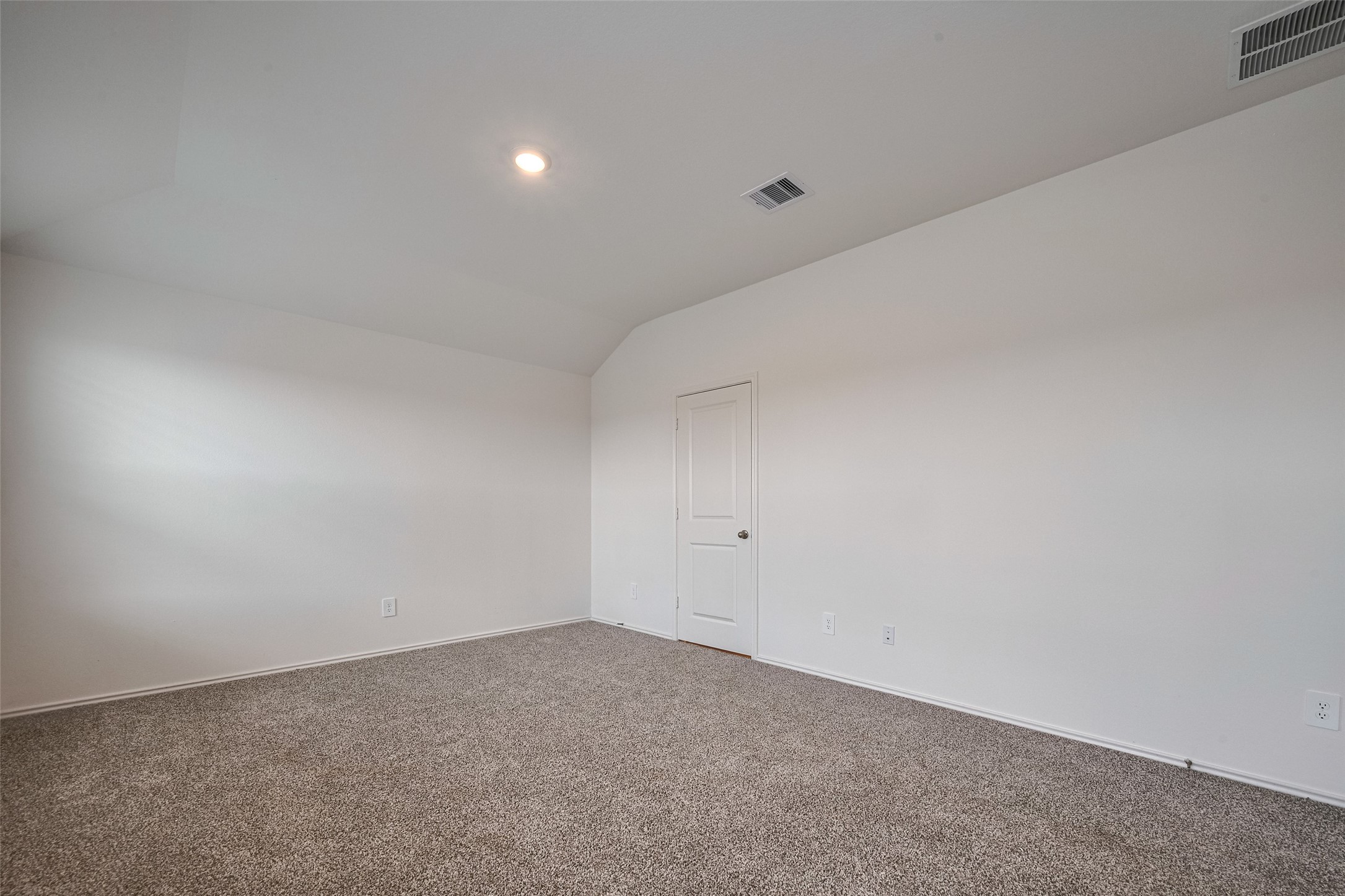 30910 Rockstock Road Fulshear, TX 77441 - Photo 25 of 33 This spacious primary bedroom features a soft sloped ceiling and expansive windows that invite in the daylight. The carpeting and airy dimensions create a serene personal space.