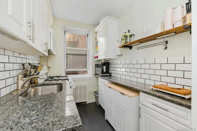 a kitchen with stainless steel appliances granite countertop a sink stove and cabinets