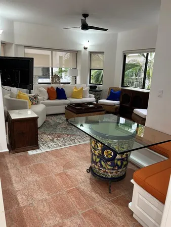 a living room with furniture a flat screen tv and a chandelier