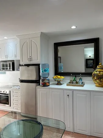 a kitchen with stainless steel appliances kitchen island granite countertop a stove a sink and a refrigerator