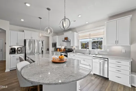 a kitchen with stainless steel appliances kitchen island granite countertop a stove and cabinets