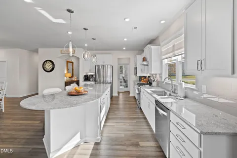 a kitchen with stainless steel appliances granite countertop a stove top oven a sink a counter space and cabinets