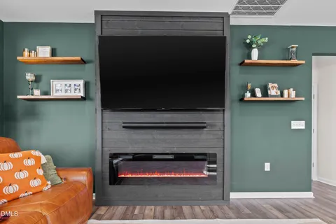 a bedroom with a large bed and a flat tv screen