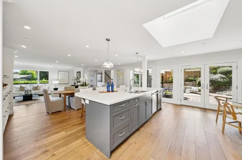 a large kitchen with kitchen island a island a sink a counter top space and living room view