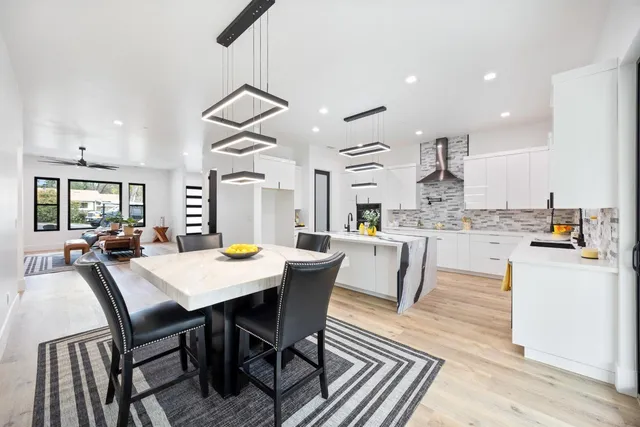 a dining room with kitchen island a table and chairs in it