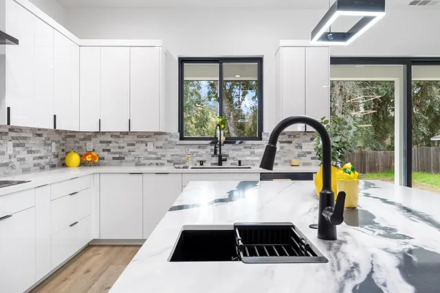 a kitchen with a sink a counter top space and stainless steel appliances