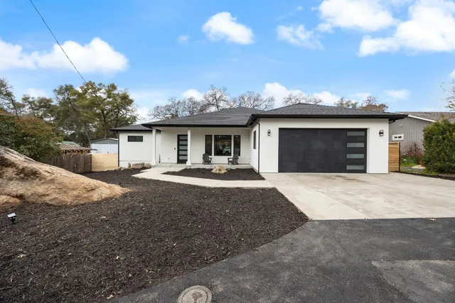 a front view of a house with a yard and garage