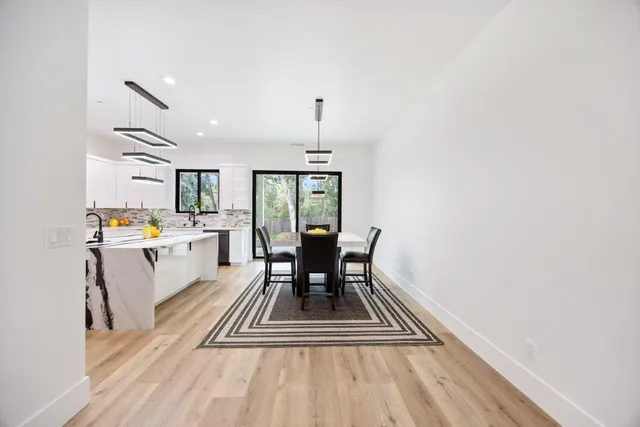 a dining room with wooden floor and a rug