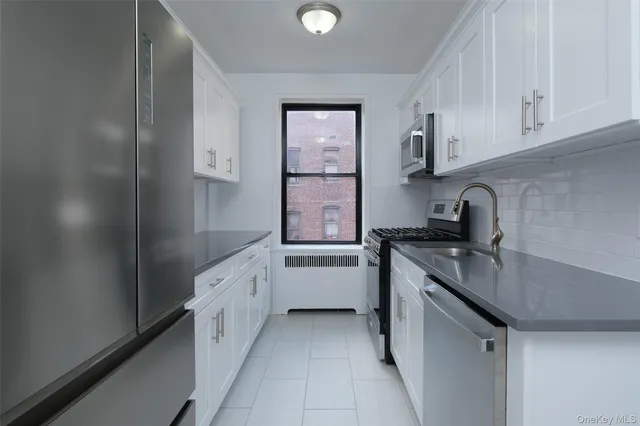 a kitchen with white cabinets and sink