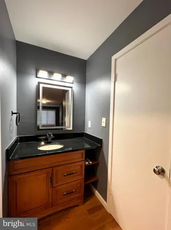 a bathroom with a granite countertop sink and a mirror