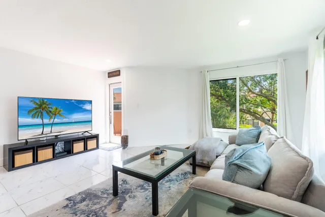 a living room with furniture a rug and a large window
