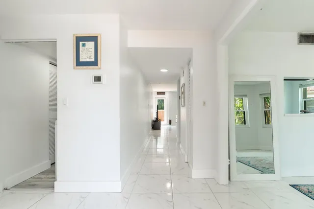 a view of a hallway with wooden floor and a living room