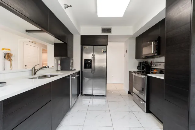 a kitchen with stainless steel appliances granite countertop a refrigerator and a sink