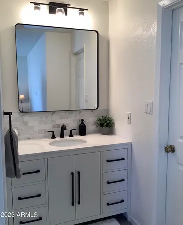 a bedroom with a bed and a flat tv screen on the dresser