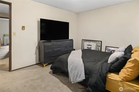a living room with a bed and a flat screen tv