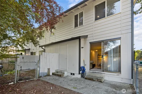 a view of a house with a small yard and wooden fence