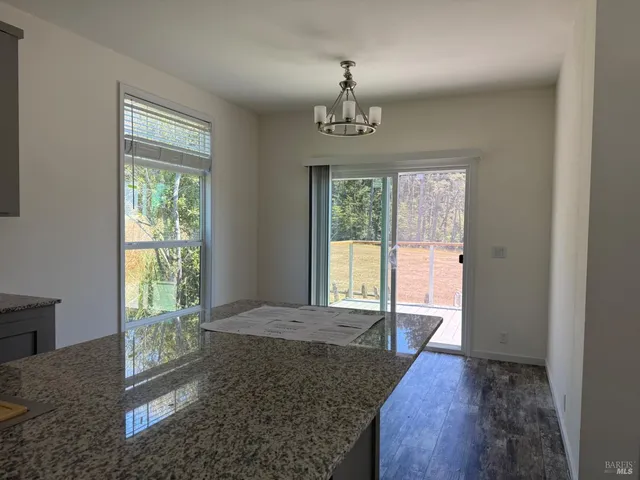 a kitchen with granite countertop a refrigerator stove and microwave