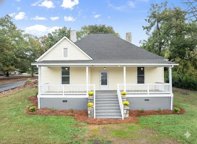 a front view of a house with a garden and plants