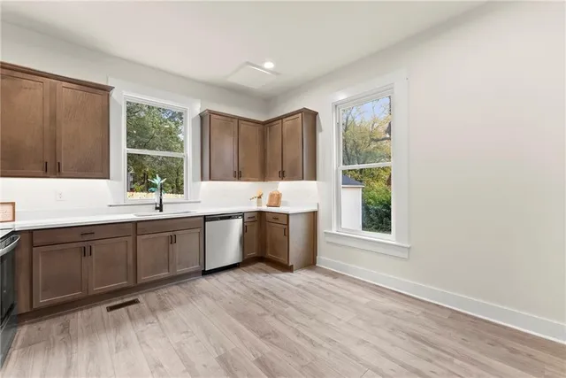 a large kitchen with a window and wooden floor