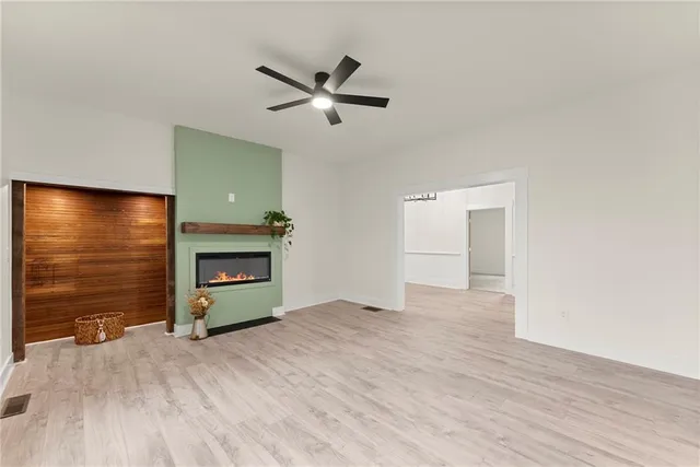 a view of empty room with wooden floor and fireplace