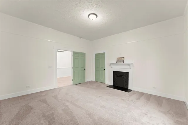 an empty room with fireplace and windows