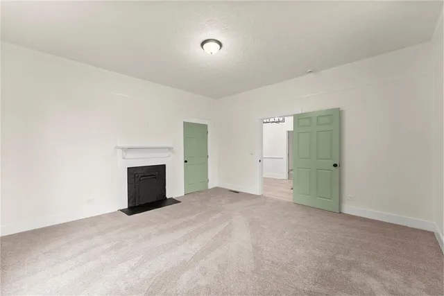 a view of empty room with a fireplace and cabinet