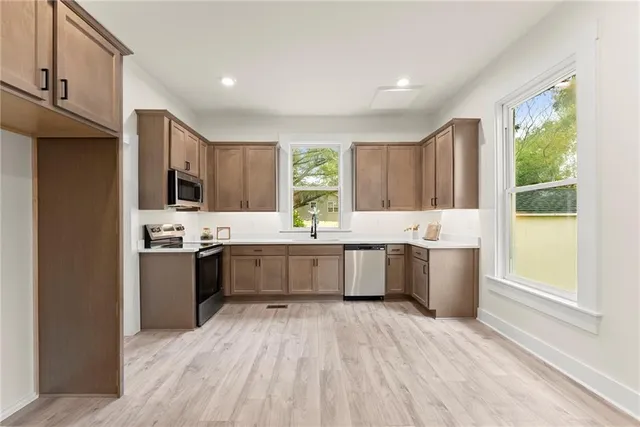 a large kitchen with a large window a sink and cabinets