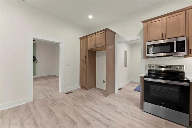 a kitchen with stainless steel appliances a stove a microwave and sink