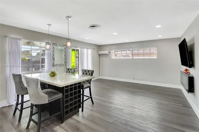 a kitchen with stainless steel appliances kitchen island granite countertop a sink refrigerator and cabinets