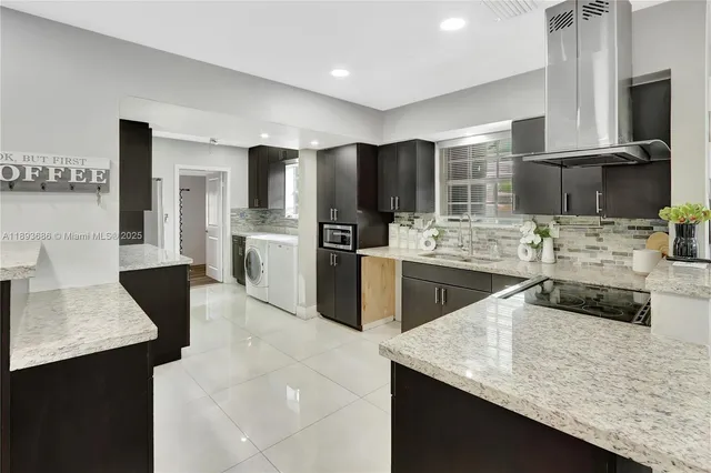 a kitchen with stainless steel appliances granite countertop a sink a stove and a refrigerator
