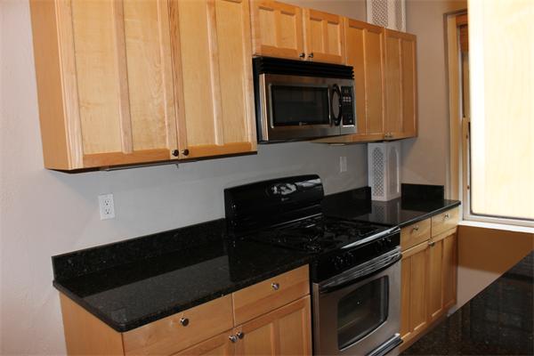 8 Chiswick Road, Unit 23 Boston, MA 02135 - Photo 3 of 15 a kitchen with granite countertop white cabinets and black appliances