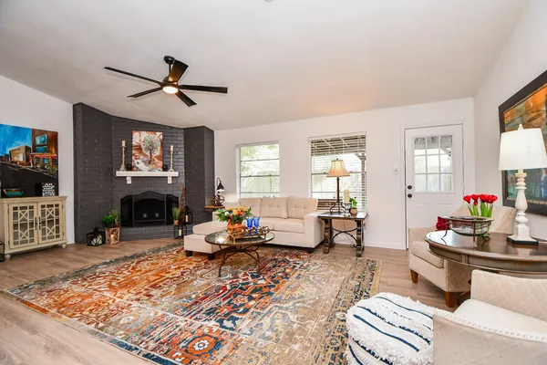 a living room with furniture a fireplace and flat screen tv