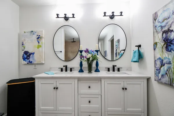 a bathroom with double vanity sinks and a mirror