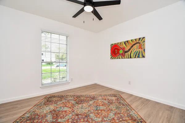 an empty room with a window and a ceiling fan