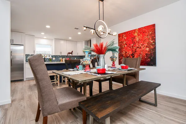 a view of a dining room with furniture a chandelier and wooden floor
