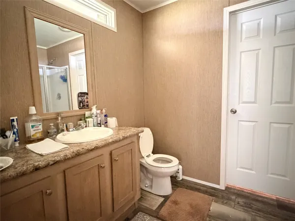 a bathroom with a granite countertop sink a toilet and a mirror